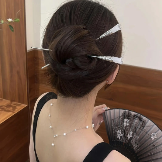 White magnolia hair pin worn in updo, model holding fan, highlighting elegance
