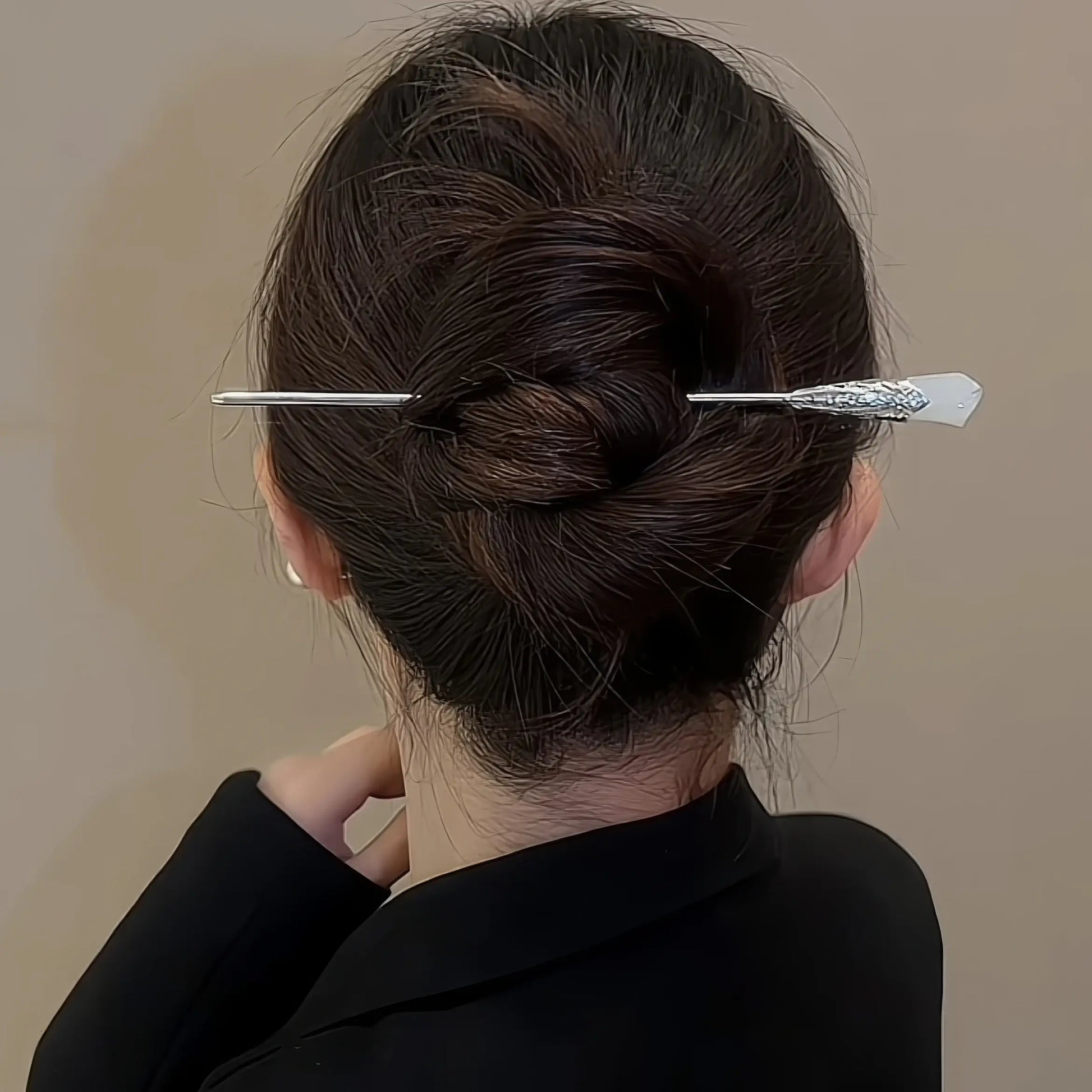 White magnolia hair pin worn in updo, model in black jacket, emphasizing style