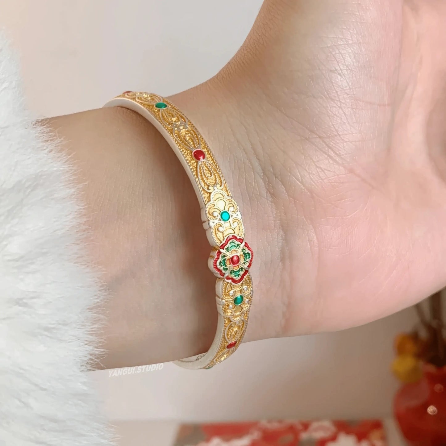 Gold white orchid bangle worn on wrist, showcasing elegance
