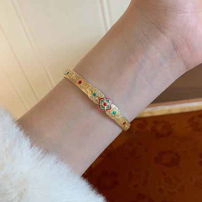 Gold white orchid bangle worn on wrist, emphasizing luxurious look