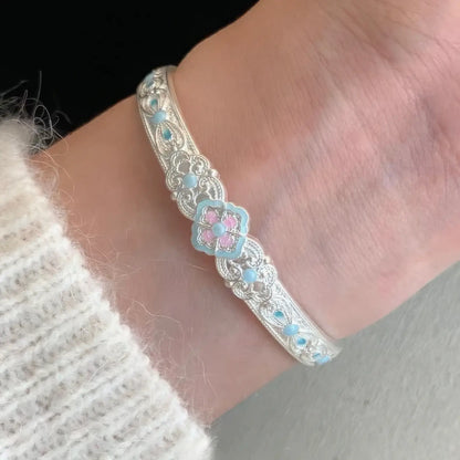 Silver white orchid bangle worn on wrist, emphasizing style