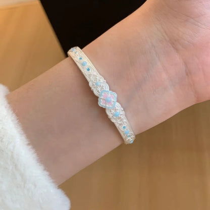 Silver white orchid bangle worn on wrist, showcasing craftsmanship