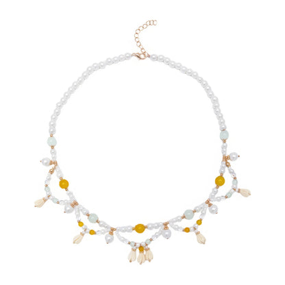 Yellow lily - of - valley necklace with pearls and beads, isolated on white background