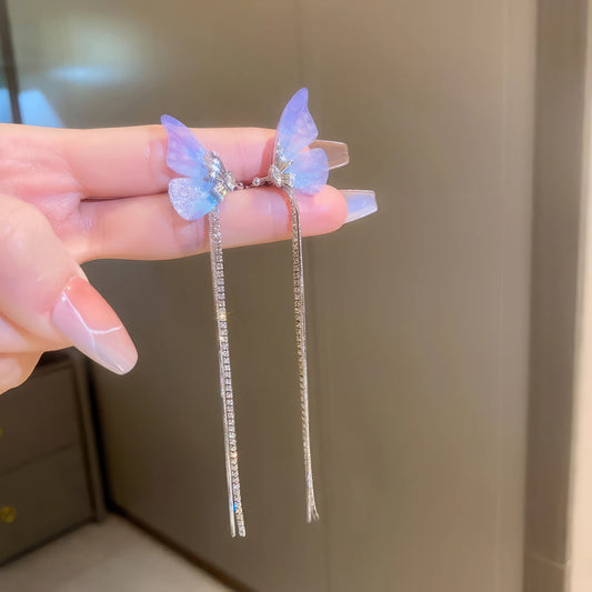 Zircon star - moon tassel ear cuff, purple butterfly accents, isolated in hand